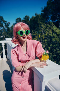 Portrait of woman wearing sunglasses while sitting on table