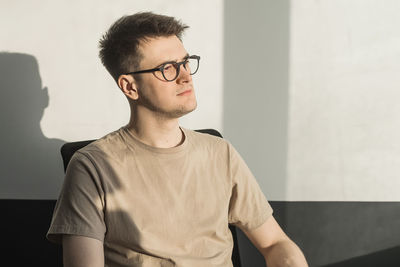 Young man standing against wall