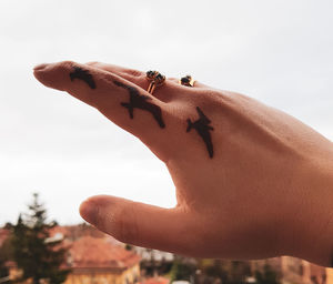 Close-up of human hand against sky