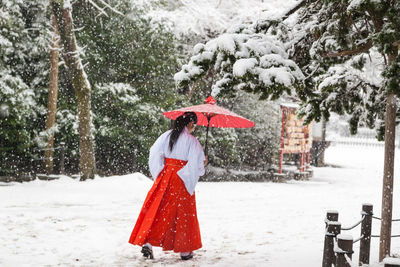 Woman standing on snow covered field