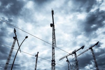 Low angle view of silhouette electricity pylon against sky