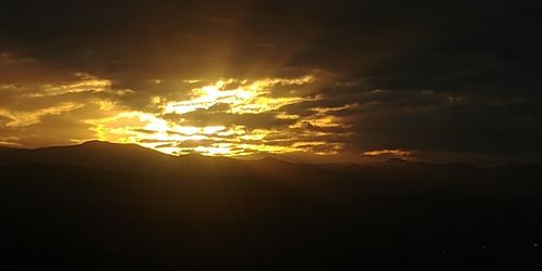 Scenic view of silhouette mountain against dramatic sky
