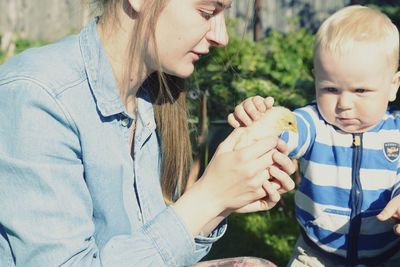 Mother with son holding a chick