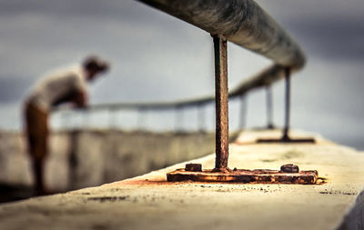 Close-up of rusty chain on beach against sky