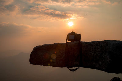 Man photographing orange sky during sunset