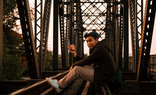 Side view of young man sitting on seat