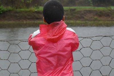 Rear view of boy standing on soccer field