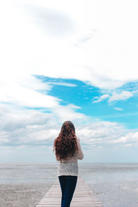 Rear view of woman standing on beach
