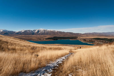Scenic view of landscape and mountains against blue sky