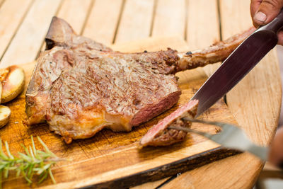 Close-up of meat on cutting board over wooden table