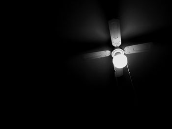 Low angle view of illuminated electric lamp in darkroom