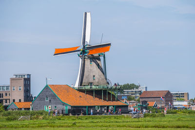 Traditional windmill on field against sky