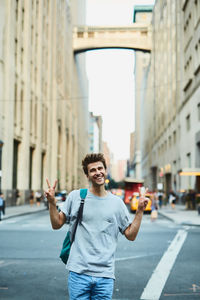 Portrait of young man standing on street in city