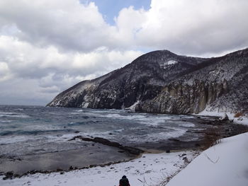 Scenic view of sea and mountains against sky