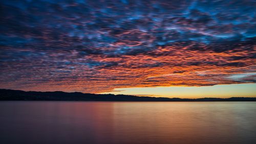 Scenic view of lake against romantic sky at sunset