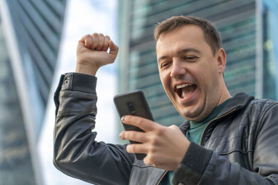 Midsection of man using mobile phone