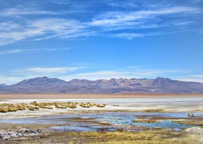 Scenic view of lake and mountains against blue sky