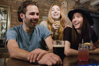 Happy young friends enjoying drinks at a bar