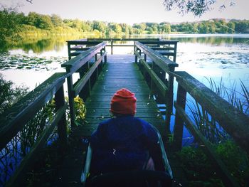 People sitting on bench by river