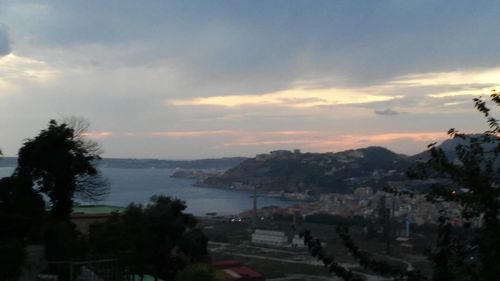 Cityscape against cloudy sky at sunset