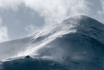 Aerial view of snow covered mountain against sky