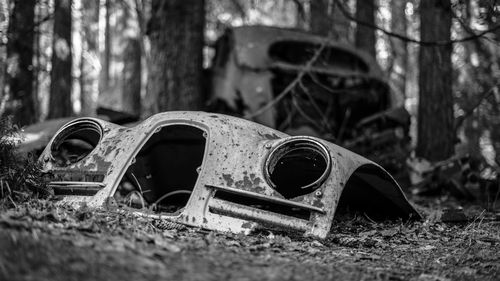 Close-up of old abandoned container on field