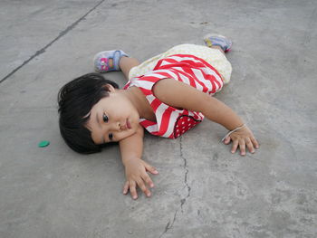 High angle view of toddler girl lying on walkway