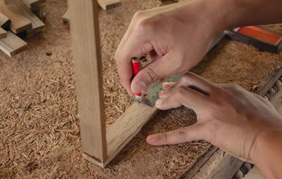 Cropped hands of man working on wood