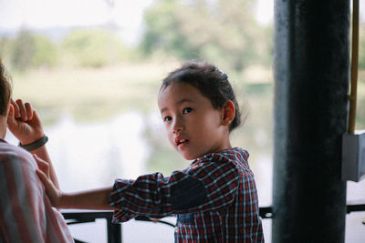 Side view of boy looking through window