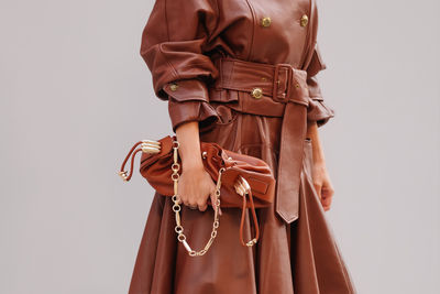 Midsection of woman standing against white background