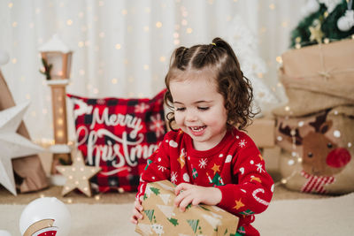 Portrait of cute girl playing with christmas tree