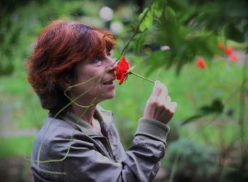 Mature woman with a rose in a park