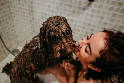 Woman washing dog in bathroom