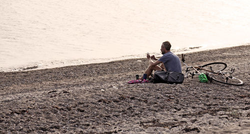 Full length of man sitting on beach