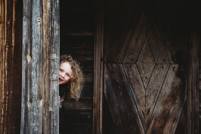 Portrait of smiling young woman looking away at entrance