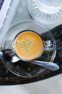 Directly above view of espresso served in glass cup with saucer