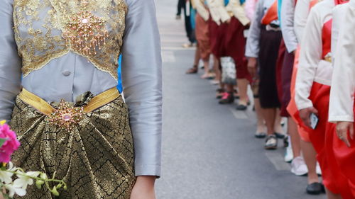 Women in traditional clothing standing on road during event in city