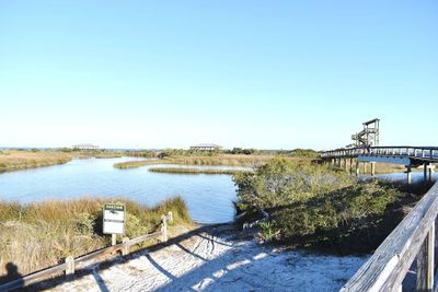 Bridge over river against clear blue sky