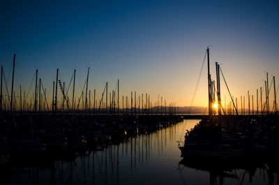 Silhouette of boats moored at sunset