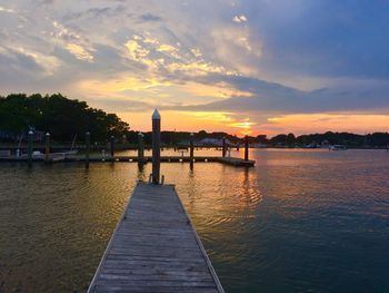 Pier on river during sunset