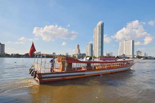 BOATS IN SEA WITH BUILDINGS IN BACKGROUND