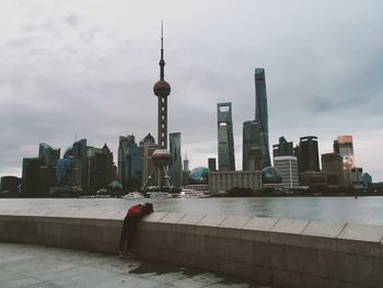 View of cityscape against cloudy sky