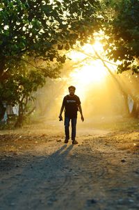 Full length of silhouette man standing on street during sunset