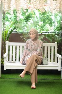 Portrait of smiling young woman sitting on seat