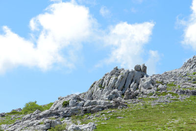 Low angle view of rocks on mountain against sky