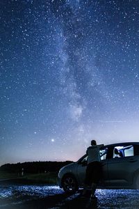 Man on car against sky at night