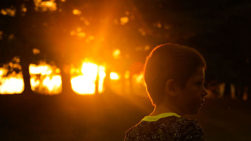 Close-up portrait of boy looking at sunset