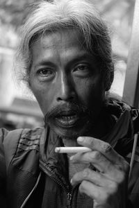 Portrait of young man smoking cigarette