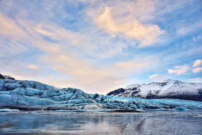 Scenic view of frozen lake against sky during sunset