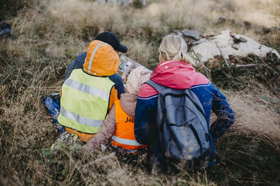 Playschool teachers reading book to children during walk